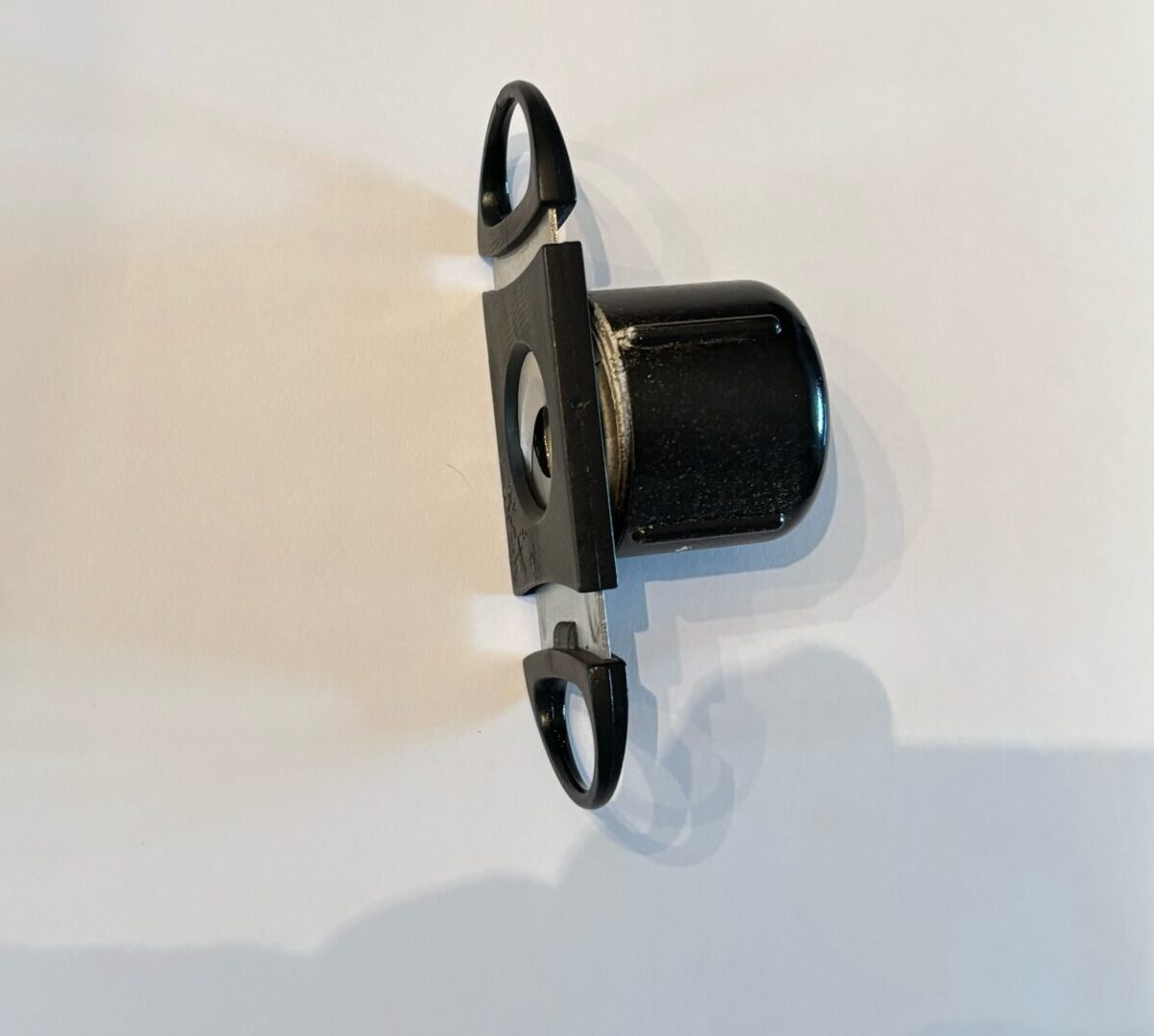 A black mechanical component featuring a cylindrical body with two looped ends, likely used in machinery or automotive applications.